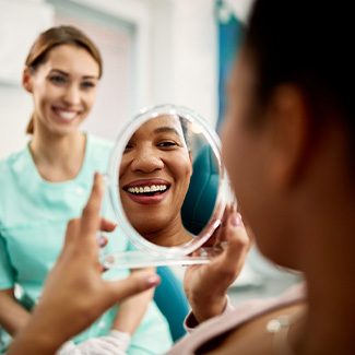 Patient smiling at reflection in treatment chair