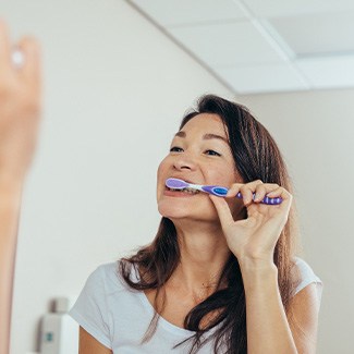 Woman brushing her teeth in bathroom