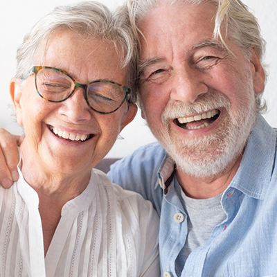 Senior woman with glasses and senior man smiling