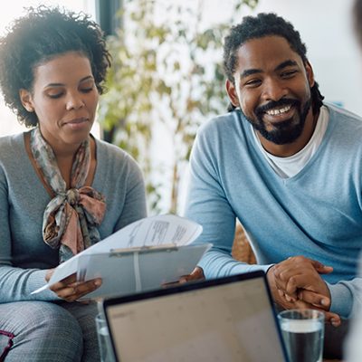 Man and woman sitting and looking over dental insurance information