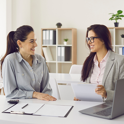 Two women sitting at table with dental insurance forms