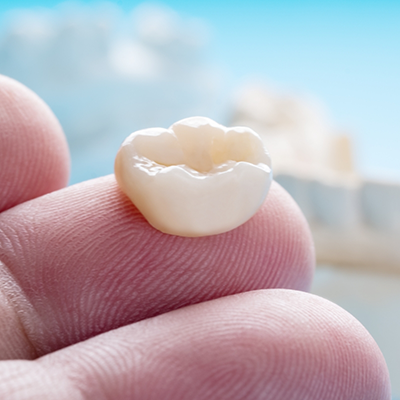 Close up of dental crown on finger