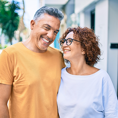 Man and woman with glasses walking down street