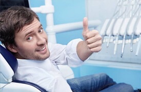 Man in dental chair giving thumbs up