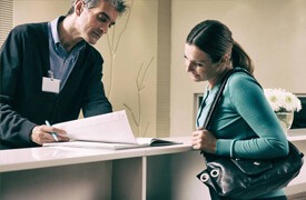 Woman checking in at reception desk