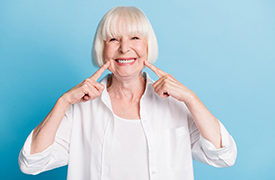 Senior woman pointing to her smile