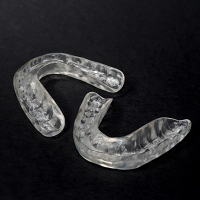 Two nightguards for bruxism on black surface