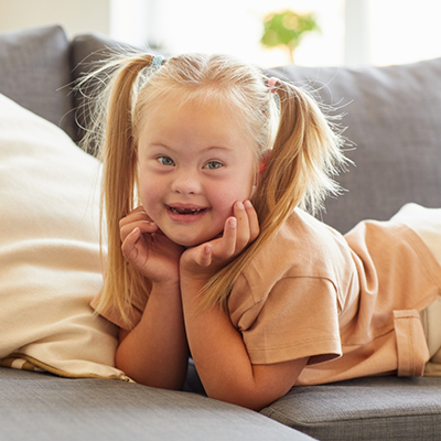 Little girl with pigtails resting on couch