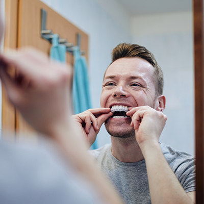 Man putting in tray for take home teeth whitening