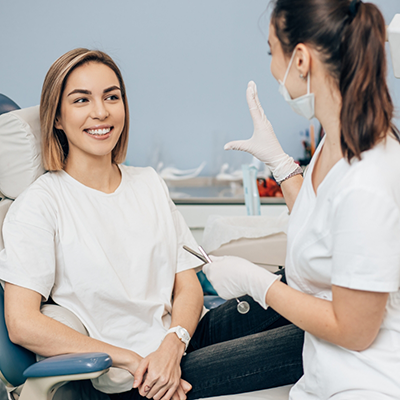 Female dentist talking to female dental patient