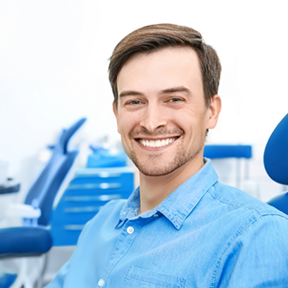 Male patient in dental chair smiling