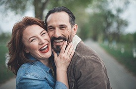 man and woman grinning and holding each other 