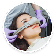 Female dental patient having nasal mask placed for sedation