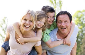 A family smiling outside.