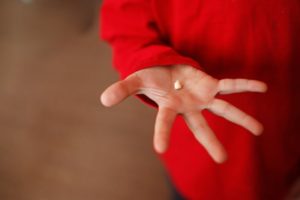 A person holding a tooth.