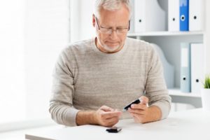 Man checkin blood sugar; diabetes