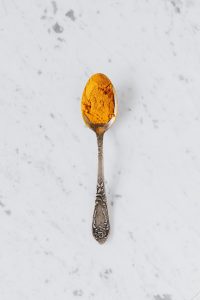 Spoon of turmeric for teeth whitening