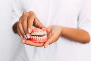 Female hands holding a set of dentures