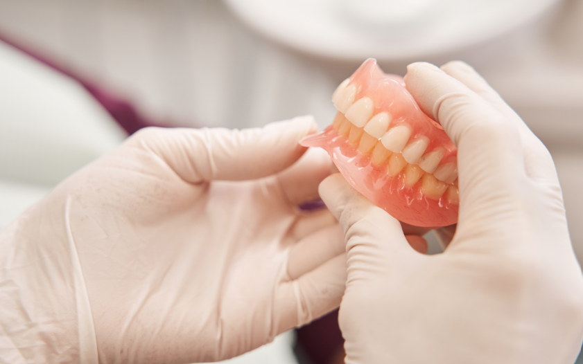 Dentist holding dentures